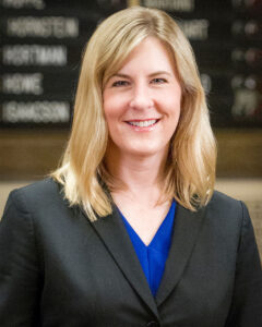 Close-up of Melissa Hortman smiling in front of a legislative board in the Minnesota State Capitol